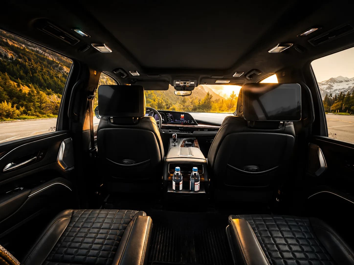Quilted leather rear cabin of the Cadillac Escalade with rear-seat screens at golden hour