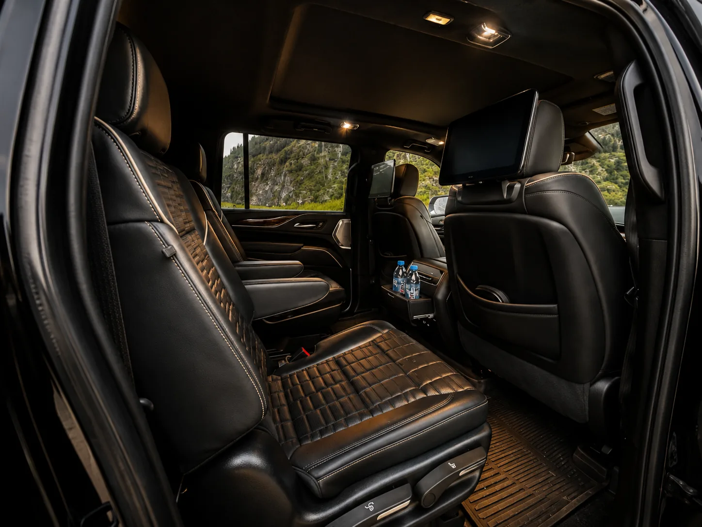 Second- and third-row quilted leather seating of the Cadillac Escalade with a rear entertainment screen