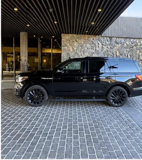 Blacked-out Lincoln Navigator in profile at a hotel entrance, Alaska private chauffeur